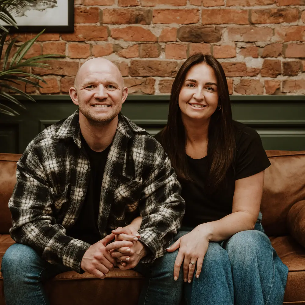 Ryan and Ashley Eccleston sitting together on a sofa at the Bespoke Foil Company studio